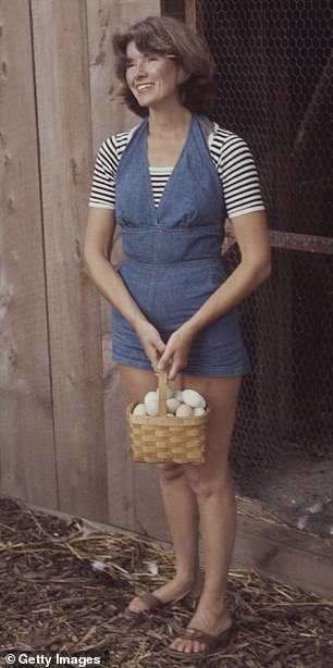 Stewart carries a basket of eggs from a chicken coop on the grounds of her home, Westport, Connecticut, August 1976