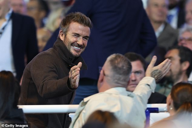 David Beckham shakes hands with fans as he joins City owner Tom Brady in the stands