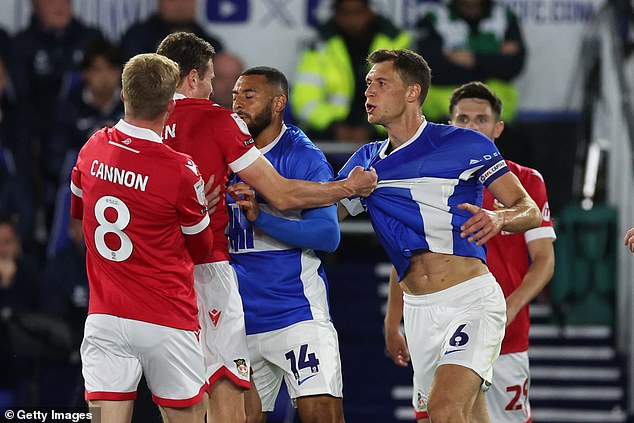 Mullin was in the thick of it as he came up against Birmingham City captain Krystian Bielik (right)