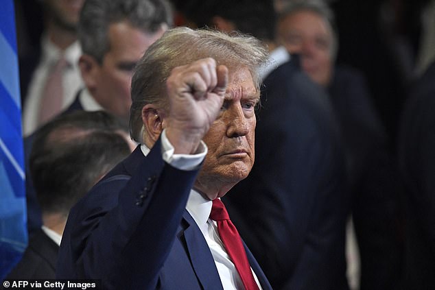 Trump gestures as he speaks to members of the press in the spin room after a presidential debate