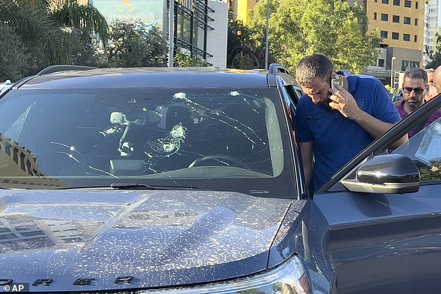 Police officers inspect a car in which a pager exploded, Beirut, Lebanon, Tuesday, September 17, 2024