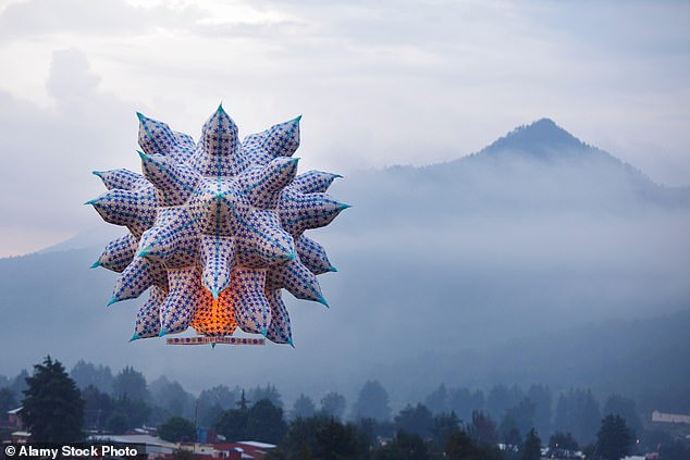 A large lantern floats toward a mountain outside Paracho, a city in the western Mexican state of Michoacán, during the annual Globos de Cantoya festival