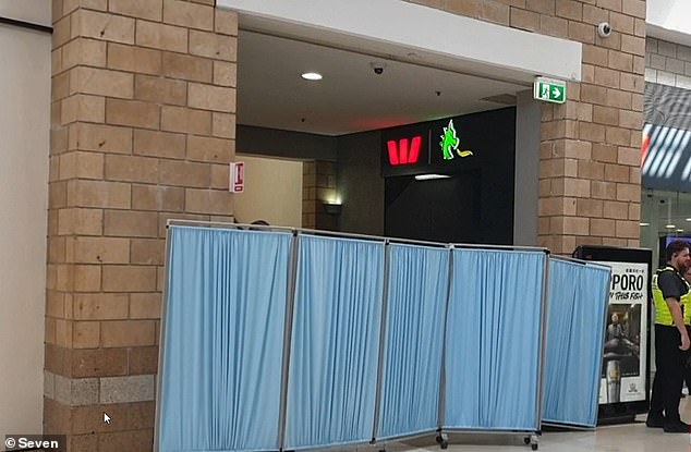 Police have cordoned off a corridor in the shopping centre with blue curtains to conduct further investigation