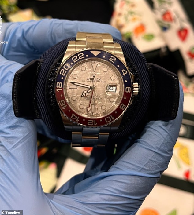 During the searches, police also seized ten cars, $800,000 in cash, a Rolex watch (pictured), four firearms, two bulletproof vests and multiple electronic devices