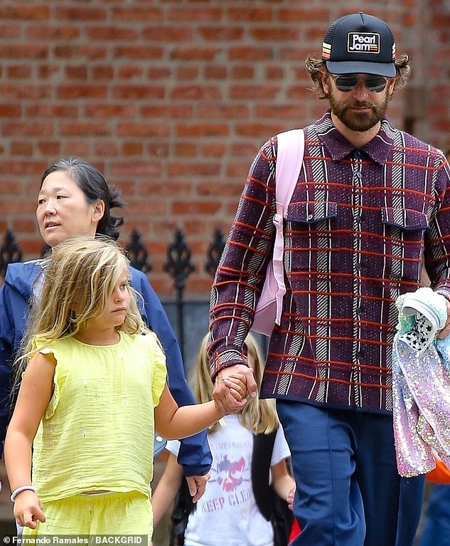 He also carried his daughter's things in an adorable way, slinging her pink backpack over his shoulder and wearing her sparkly jacket