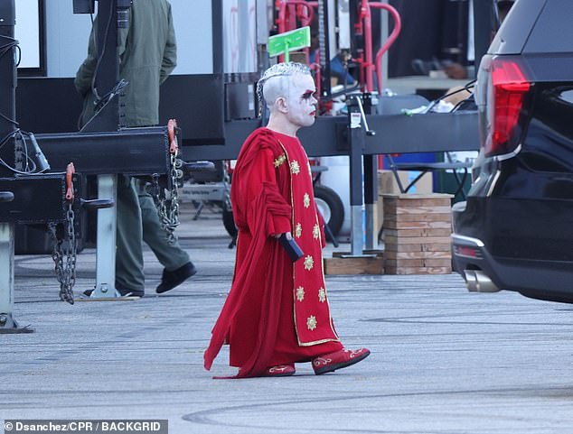 His face was covered in dramatic villain makeup, consisting of white face paint, heavy black and red eye shadow, and red lipstick