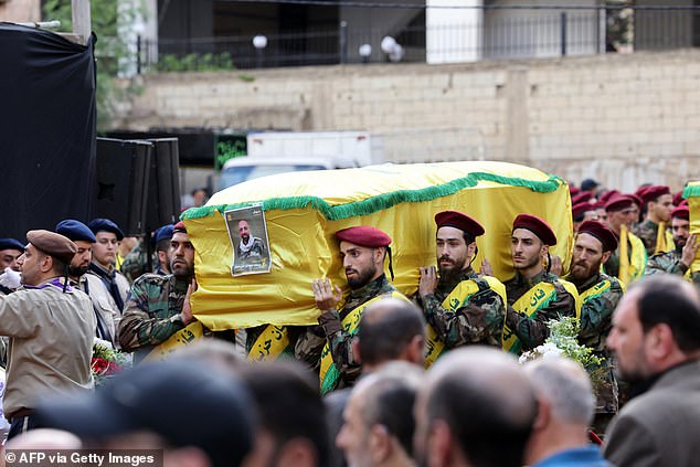 Hezbollah fighters carry the coffins of a person killed after hundreds of beepers exploded in a deadly wave in Lebanon the day before, September 18