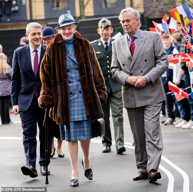 Queen Margrethe is pictured smiling as crowds gather to watch her journey to open the new Prince Henriks Skole