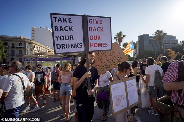 A protester holds a sign reading 'Take back your drunks, give back our homes' during a demonstration in Palma this month