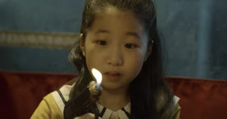 Player 456's daughter holds a lighter in the shape of a gun