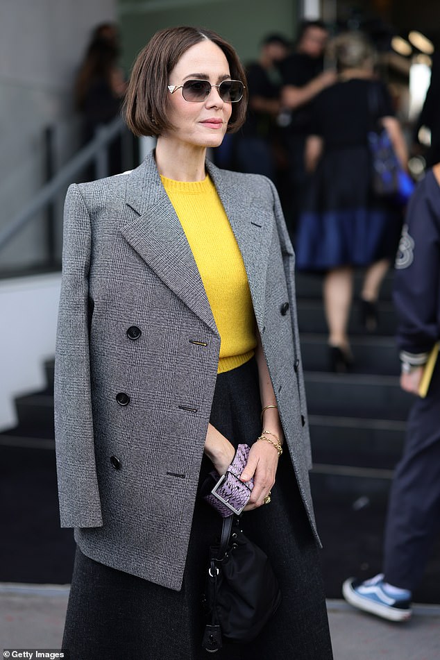 Sarah Paulson added a pop of color to the FROW with her bright yellow sweater, paired with a full black skirt