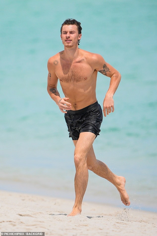 Wearing dark swim trunks, Shawn showed off his toned abs as he took a shirtless dip. He was seen running across the sand after getting out of the water