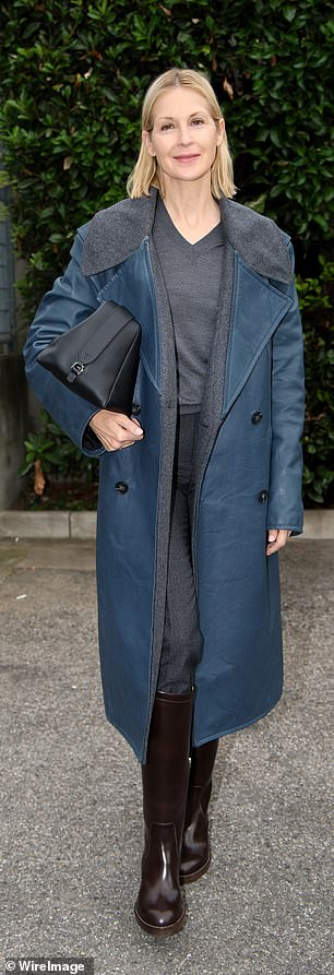 The actress wore a fur-lined blue leather trench coat over her gray skirt and sweater, and added a pair of patent leather boots and a simple black clutch to her look.