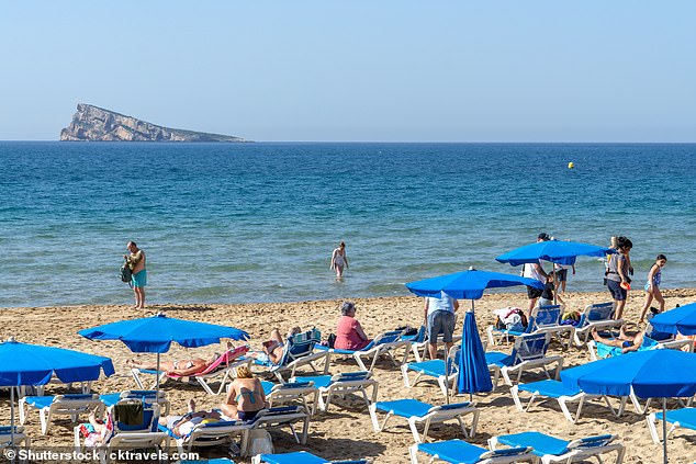 Tourists sunbathing on the beach in Benidorm, Spain