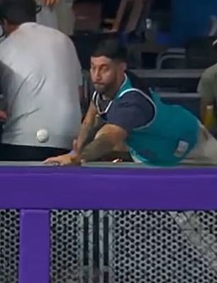 A Marlins fan tries to catch the ball from Ohtani