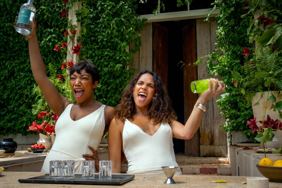 Two women with shakers in their hands and happily shouting in Blink Twice.