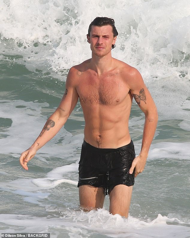 He was seen dripping in the water, wearing only black swimming trunks, as he gave fans a glimpse of some of his 17 tattoos