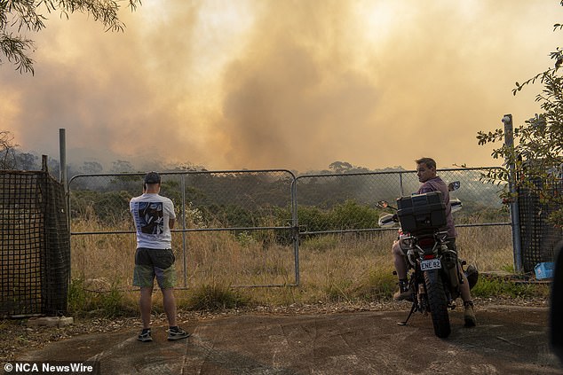 Residents are being urgently evacuated from Sydney's Northern Beaches as firefighters battle an out-of-control blaze (smoke from the fire is seen in the picture)