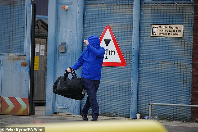 A person believed to be a prisoner hides his face as he leaves HMP Liverpool as 1,700 inmates are released early under a government programme to ease overcrowding