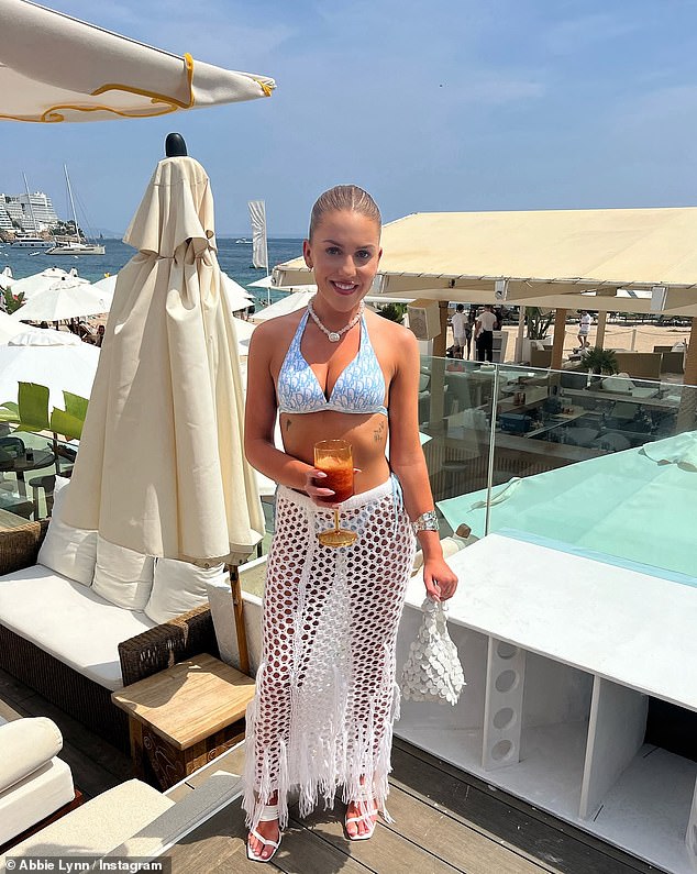 Just a few weeks ago, Abbie was sunbathing in Mallorca. In one photo, she is seen wearing a blue bikini and a white crochet skirt as she poses on Nikki's beach.