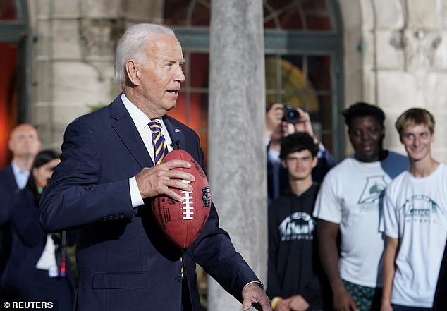 Biden pretends to throw a pass while visiting members of the football team at Archmere Academy, his former school and site of the upcoming Quad Summit in Claymont, Delaware