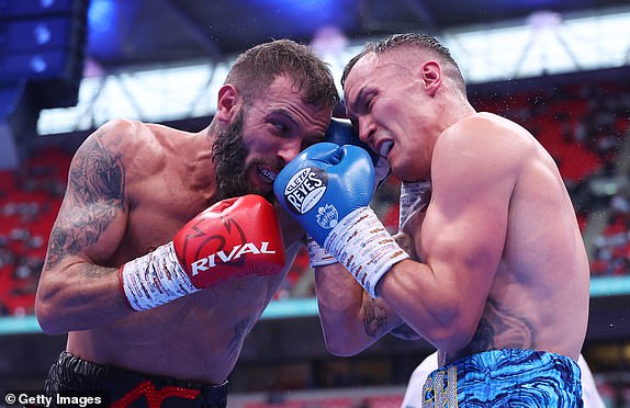 LONDON, ENGLAND - SEPTEMBER 21: Josh Warrington and Anthony Cacace exchange punches during the IBO World Super Featherweight Title fight between Anthony Cacace and Josh Warrington, on the Riyadh Season - Wembley Edition card at Wembley Stadium on September 21, 2024 in London, England. (Photo by Richard Pelham/Getty Images)