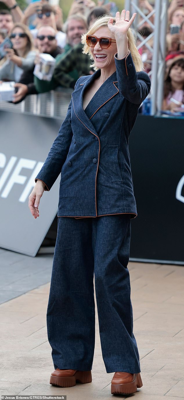 To match the subtle details of her top, she wore brown leather mules and oversized tinted sunglasses