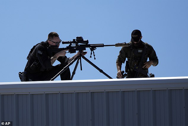 Police take up position on a rooftop during the event in North Carolina