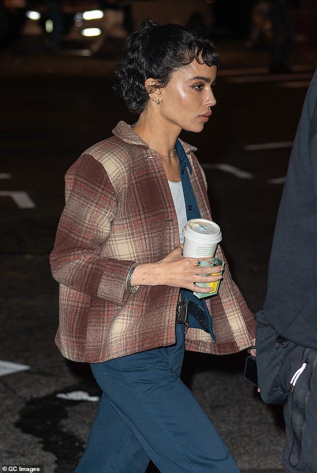 She was seen crossing the street and walking around the set with crew members, carrying a take-away coffee cup and pack of cigarettes in one hand and her cell phone in the other.