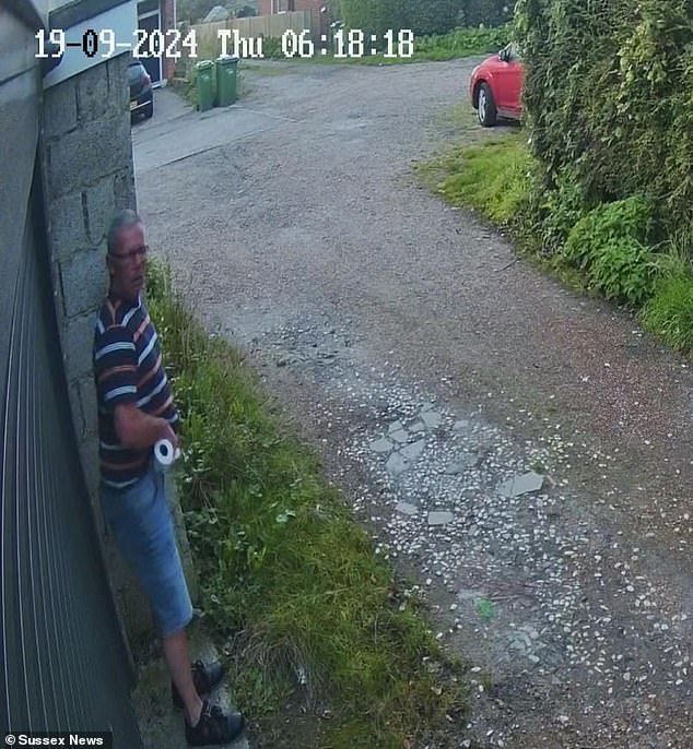 CCTV footage taken on Thursday morning shows a man standing in the corner of a garage on what appears to be a residential street with a toilet roll in one hand