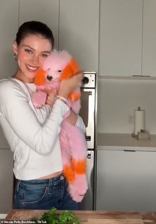 The 29-year-old actress looked happier than ever in her latest video as she snuggled up to the Bolognese dog, who is normally white in color