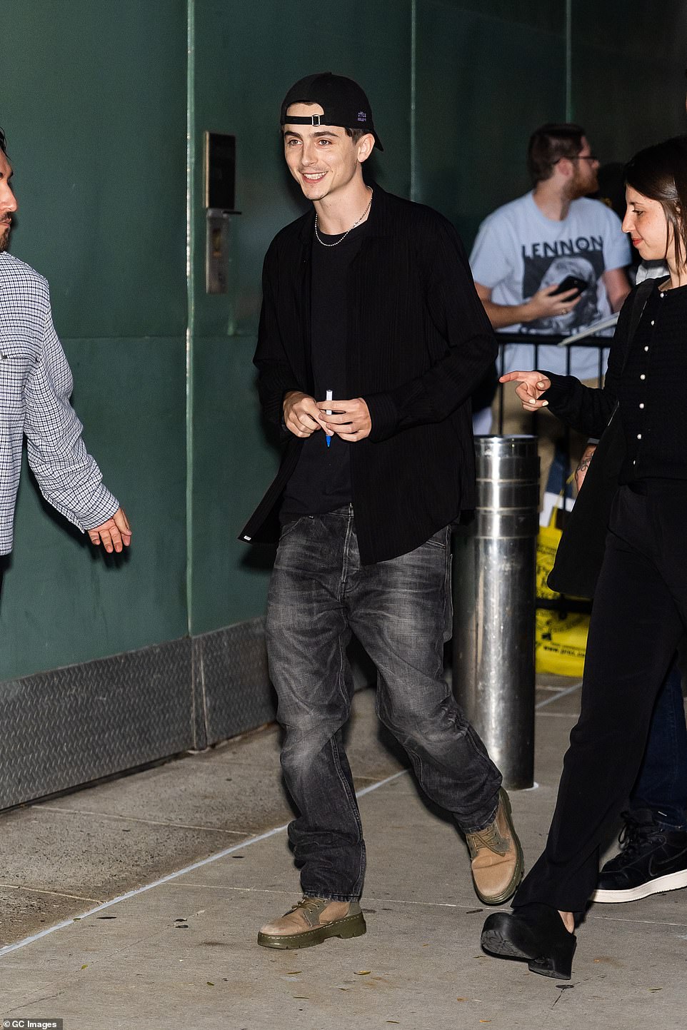 The French-American actor, 28 — who is dating Kylie Jenner — teamed his look with tan boots and a gold chain. Chalamet wore a backwards hat and appeared to be in good spirits as he signed autographs with his costars