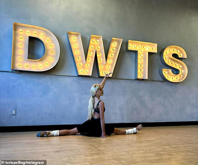 The 51-year-old Beverly Hills 90210 star, who was announced earlier this month as a contestant on the dance competition, showed off her flexibility on Instagram on Saturday as she posed behind a light-up DWTS sign