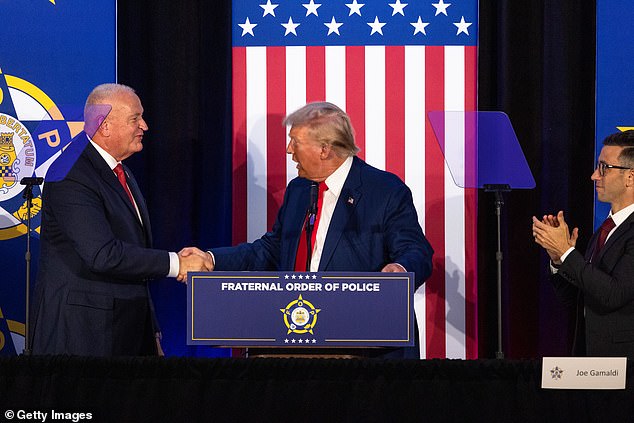 Donald Trump shakes hands with the president of the Fraternal Order of Police in Charlotte, NC on September 6