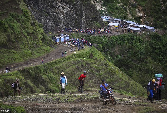 Crossing the Haiti-Dominican Republic border overland is extremely risky, as travelers can face hefty immigration fines and threats of kidnapping and violence, as the roads are where these types of incidents are most likely to occur. Pictured: People trek through the mountains to avoid gang violence in the Kenscoff neighborhood of Port-au-Prince, Haiti on September 10