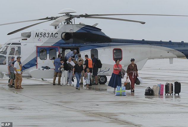 A 'hotbed' of carjackings and armed robberies has been concentrated at the Aeroport International Toussaint Louverture in the municipality of Port-Au-Prince - often targeting single drivers and women. Pictured: People evacuated from Haiti by a U.S. helicopter arriving at Las Americas Airport in Santo Domingo, Dominican Republic, on March 22