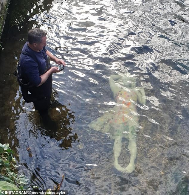 Jason deClaires Taylor stands next to the Alluvia statue in the River Stour in his hometown of Canterbury