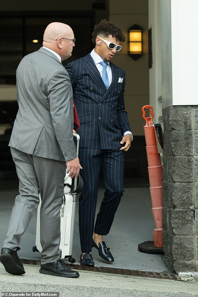 Patrick Mahomes also dressed up, wearing a navy pinstripe suit and baby blue tie