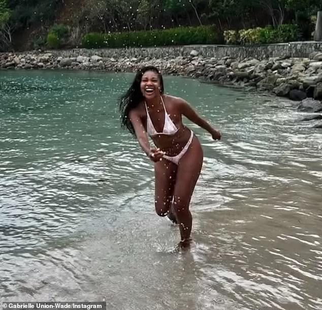 The raven-haired beauty shared clips of herself frolicking on the beach in a sexy floral bikini, showing off her ageless beauty