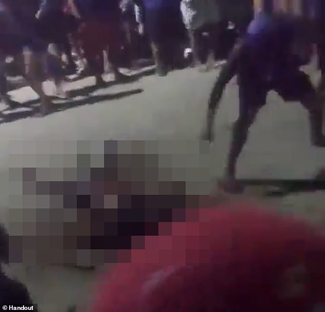 A resident approaches the body of Gregorio da Silva and sets it on fire after the 48-year-old was dragged from a police station in Amazonas, Brazil, moments after he allegedly confessed to the rape and murder of one-year-old Layla Vitória