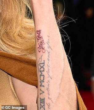 Angelina's 'Stay Gold' tattoo is located on the side of her arm, next to two other tattoos - in cursive; seen on April 11 in NYC