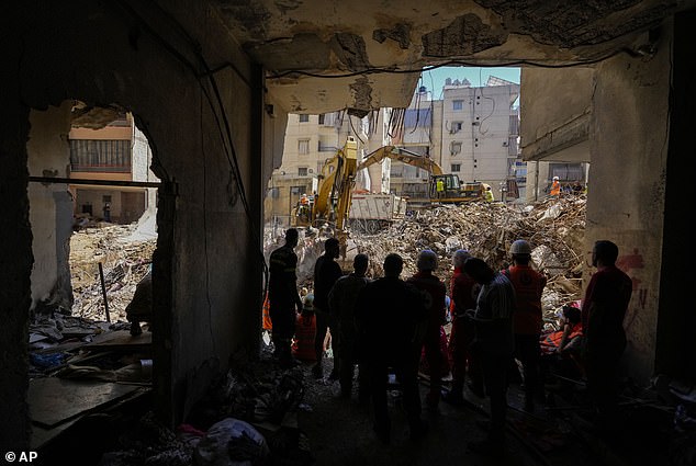 Aid workers use excavators to clear rubble at the site of Friday's Israeli attack on Beirut's southern suburbs