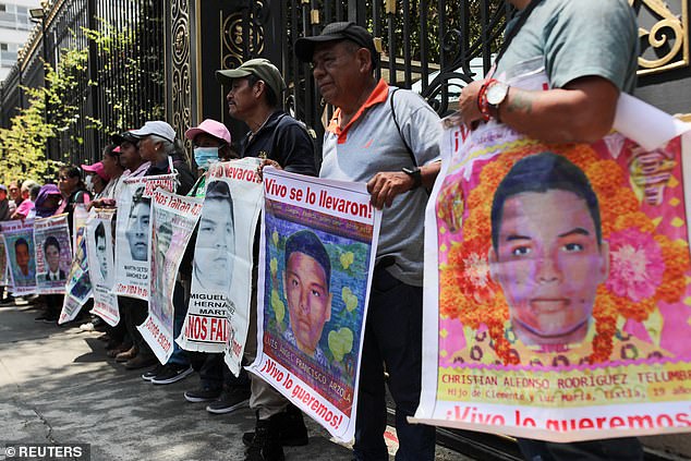 Families hold signs for 43 teachers' college students who were allegedly murdered by a drug gang in Iguala, a city in the Pacific coastal state of Guerrero, on September 26, 2014. The parents and classmates have demanded justice from the administration of President Andrés Manuel López Obrador