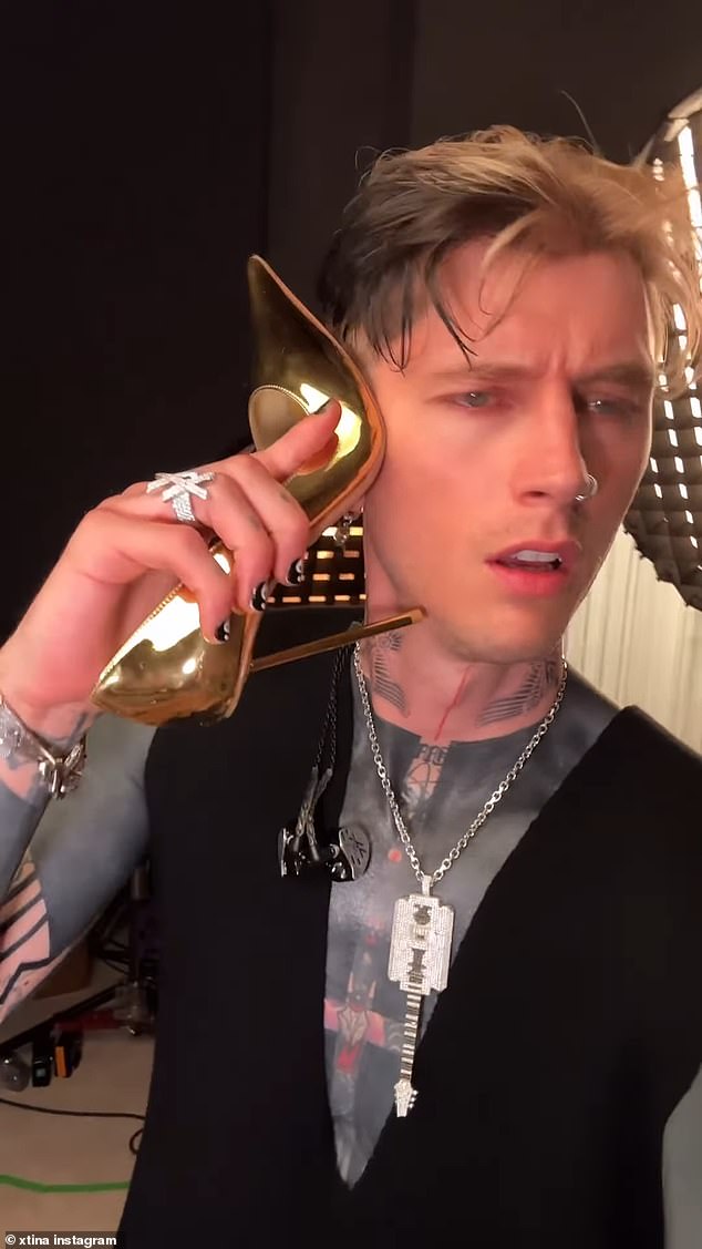 In the video, uploaded to her Instagram account, the singer can be seen filming herself sitting on a pink suede couch before turning the camera on Machine Gun Kelly, who holds one of her high heels to his ear as if answering the phone.