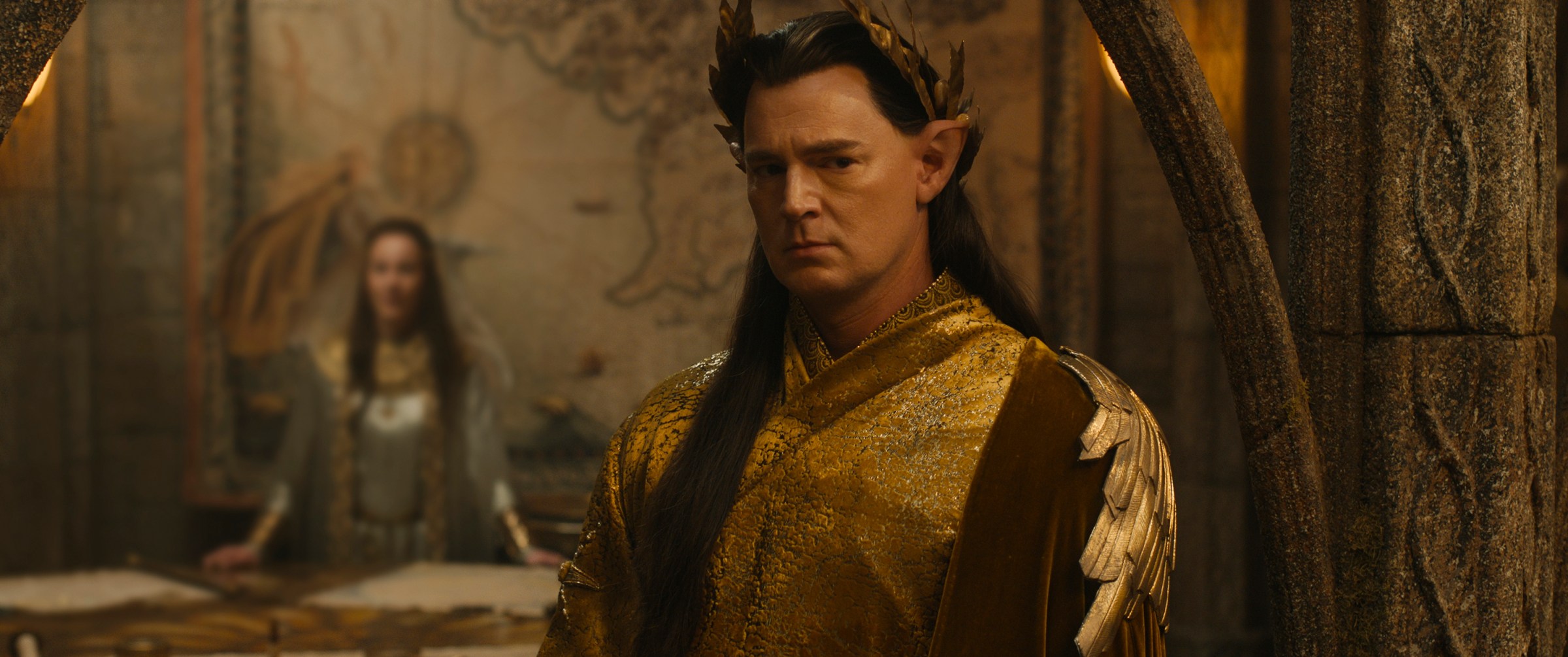 Elven High King Gil-galad (Benjamin Walker), a stern-looking, dark-haired elf in a crown, looks pensive in The Rings of Power