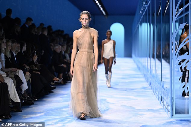 A model wore a stunning gold sheer halter dress on the runway