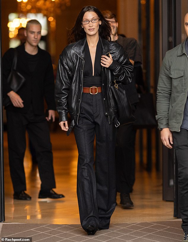 She opted for a pair of high-waisted, wide-leg, pinstripe trousers and cinched her waist with a thick brown belt