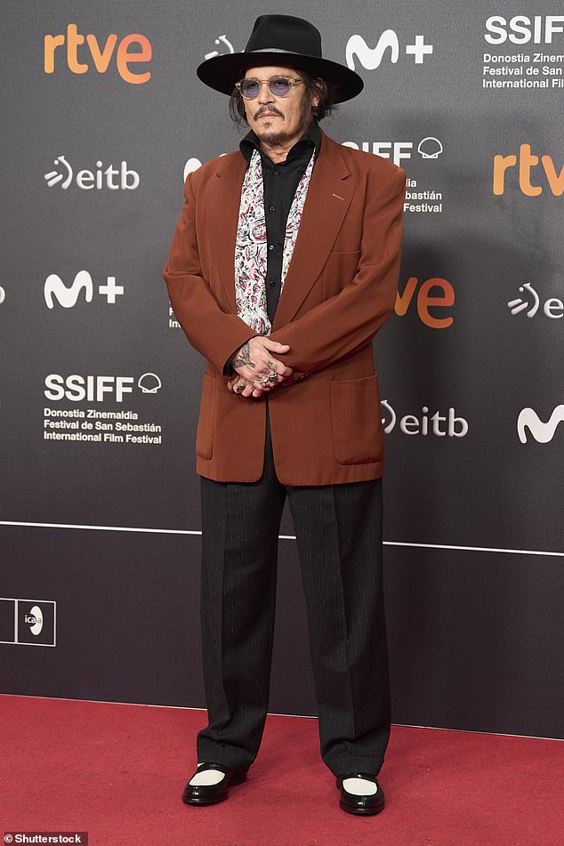 The actor completed his look with a burnt red suit jacket, black pants and black and white shoes