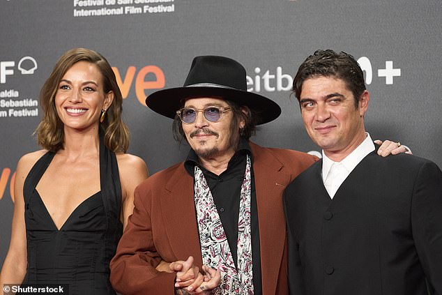 Depp appeared on the red carpet in a black shirt with a white scarf over his shoulders