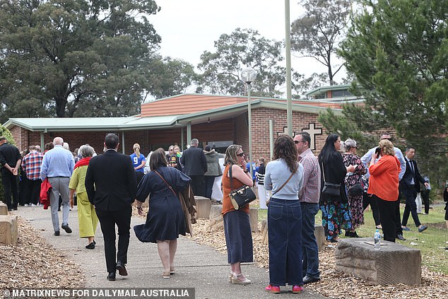 Mourners arrive at St. Thomas Aquinas Catholic Church in Springwood Wednesday morning for the funeral of Russell, 11, and Ben, nine.